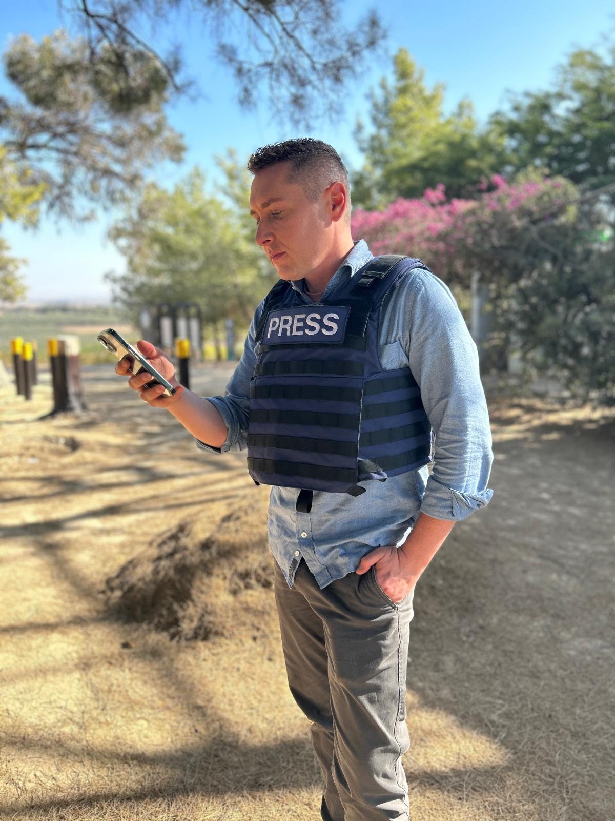 Josh Lederman reporting from the field in a press vest